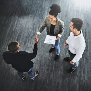 Business people, shaking hands and contract at office, above and documents for deal, team or respect at startup. Woman, men and b2b partnership for collaboration, onboarding or diversity at company REST